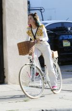 LUCY HALE Riding a Bike on a Movie Set in Los Angeles 05/08/2022