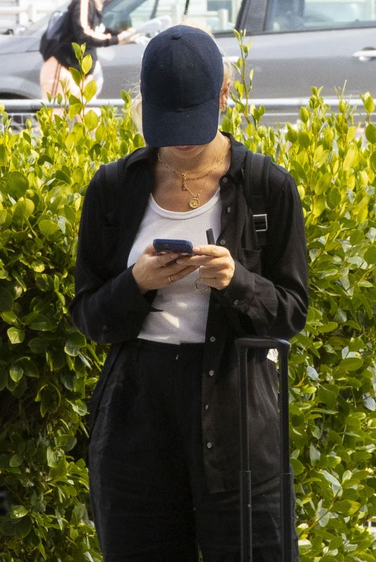 LILY JAMES Arrives at Heathrow Airport in London 08/03/2022