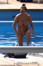 Pregnant CHRISSY TEIGEN in Bikini at a Pool at Lake Como 08/28/2022