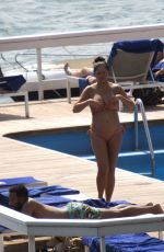 Pregnant CHRISSY TEIGEN in Bikini at a Pool at Lake Como 08/28/2022