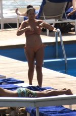 Pregnant CHRISSY TEIGEN in Bikini at a Pool at Lake Como 08/28/2022