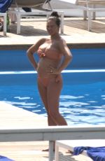 Pregnant CHRISSY TEIGEN in Bikini at a Pool at Lake Como 08/28/2022