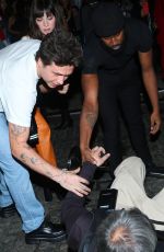 NICOLA PELTZ and Brooklyn Beckham Help an a Photographer at a Vogue Runway Show in New York 09/12/2022