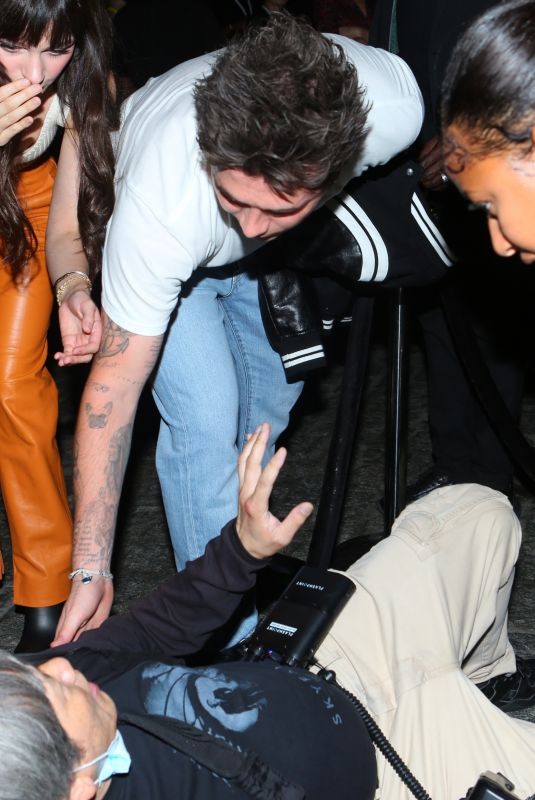 NICOLA PELTZ and Brooklyn Beckham Help an a Photographer at a Vogue Runway Show in New York 09/12/2022