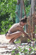 CLARA BERRY in Bikini Picking the Trash from the Beach in Tulum 11/19/2022
