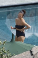 CHRISSY TEIGEN in Swimsuit at a Swimming Pool in Lake Como 09/14/2023