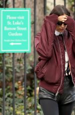 IRINA SHAYK in Black Leather Hot Pants, Black Stockings, Black Boots and Maroon Jacket Out in New York 12/04/2023