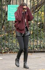 IRINA SHAYK in Black Leather Hot Pants, Black Stockings, Black Boots and Maroon Jacket Out in New York 12/04/2023