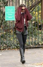 IRINA SHAYK in Black Leather Hot Pants, Black Stockings, Black Boots and Maroon Jacket Out in New York 12/04/2023