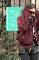 IRINA SHAYK in Black Leather Hot Pants, Black Stockings, Black Boots and Maroon Jacket Out in New York 12/04/2023