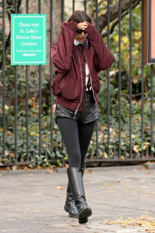 IRINA SHAYK in Black Leather Hot Pants, Black Stockings, Black Boots and Maroon Jacket Out in New York 12/04/2023