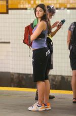 SURI CRUISE in a Cut-off Sweatpants, a Tank Top and Colorful Sneakers Waiting for Subway in New York 08/10/2024