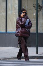 IRINA SHAYK in a Plum-colored Puffer Coat, Dark Brown Pants and Sleek Black Boots Out in New York 10/28/2024
