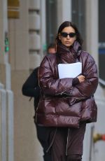 IRINA SHAYK in a Plum-colored Puffer Coat, Dark Brown Pants and Sleek Black Boots Out in New York 10/28/2024