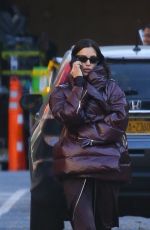 IRINA SHAYK in a Plum-colored Puffer Coat, Dark Brown Pants and Sleek Black Boots Out in New York 10/28/2024