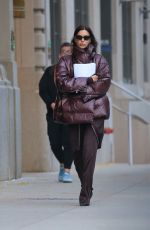 IRINA SHAYK in a Plum-colored Puffer Coat, Dark Brown Pants and Sleek Black Boots Out in New York 10/28/2024