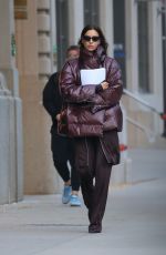IRINA SHAYK in a Plum-colored Puffer Coat, Dark Brown Pants and Sleek Black Boots Out in New York 10/28/2024