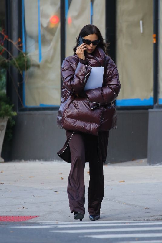 IRINA SHAYK in a Plum-colored Puffer Coat, Dark Brown Pants and Sleek Black Boots Out in New York 10/28/2024