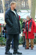 LIZA KOSHY on the Set of The Man with the Bag with Arnold Schwarzenegger, Alan Ritchson and KYLE MOONEY in Bryant Park in New York 12/19/2024