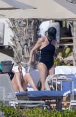 CHARLIZE THERON in a Black Swimsuit at a Pool in Cabo 12/30/2024