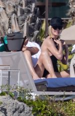 CHARLIZE THERON in a Black Swimsuit at a Pool in Cabo 12/30/2024