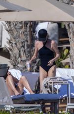 CHARLIZE THERON in a Black Swimsuit at a Pool in Cabo 12/30/2024