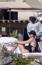 CHARLIZE THERON in a Black Swimsuit at a Pool in Cabo 12/30/2024