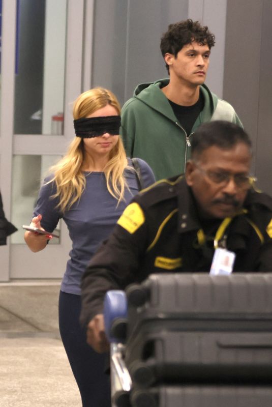 ADDISON RAE Wears a Blindfold at LAX Airport in Los Angeles 11/19/2025