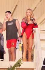 BROOKS NADER in a Red Swimsuit on the Set of Baywatch Reboot at Venice Beach 03/19/2026