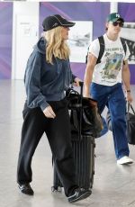 ELLIE GOULDING and Beau Minniear Jet Out of London Ahead of Taylor Swift